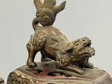 bronze statue of a lion on a pedestal with a bird on its back