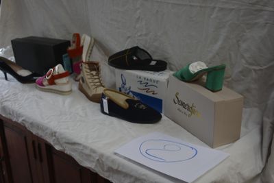 several pairs of shoes are lined up on a table next to a box
