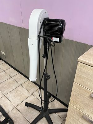 une photo d'un sèche-cheveux posé sur un support dans une pièce