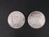two silver coins, one with a crown and the other with a coat of arms