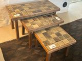 two tables with tile on them sitting on a rug
