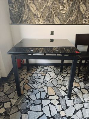une table à manger et deux chaises dans une pièce ornée d'une grande peinture murale