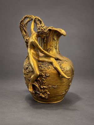un vase ancien doré sur lequel est assise une femme