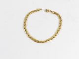 un bracelet à chaîne en or avec un fermoir sur fond blanc