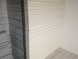 a large stack of white cardboard stacked up against a wall