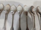 six cuillères sont alignées sur une table