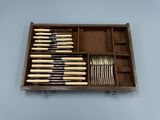 une boîte en bois contenant un ensemble de couteaux et de cuillères