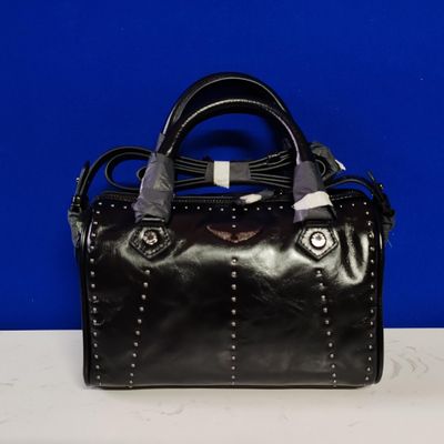 a black purse with a silver handle on a white table