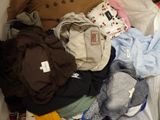 une pile de vêtements posée sur un lit