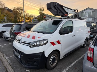 une camionnette blanche avec une bande rouge garée sur un parking