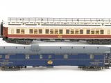 four miniature trains that are lined up on a white surface