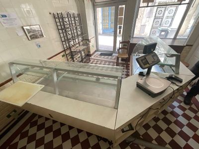 un homme debout devant un comptoir, face à une vitrine en verre