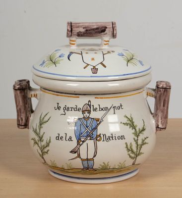 un pot en céramique orné d'un soldat, posé sur une table