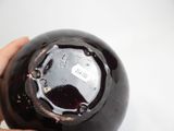 a person holding a black vase in their hand