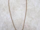 gold plated necklace with a flower pendant on a gold chain