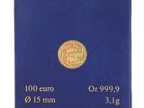 un gros plan d'une boîte bleue sur laquelle repose une pièce d'or