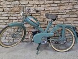 une moto bleue garée contre un mur de briques