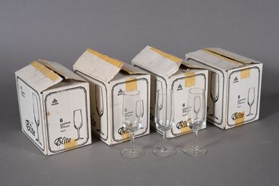 four wine glasses are sitting in a row next to a box