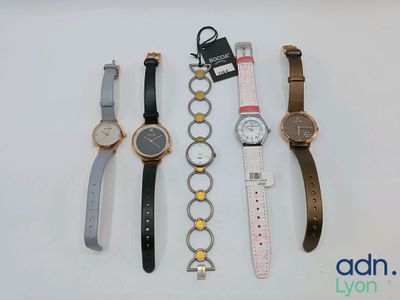 quatre montres différentes sont alignées sur une surface blanche