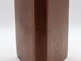 livre relié en cuir marron, avec des pages dorées sur fond blanc