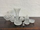 several pieces of glass sitting on a wooden table with a white wall in the background