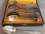 six silver spoons in a box with a yellow lining