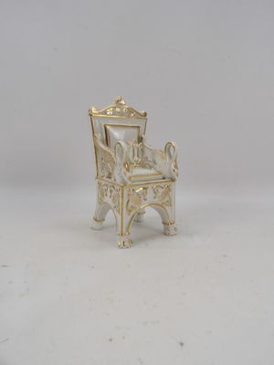 une chaise miniature posée sur une surface blanche