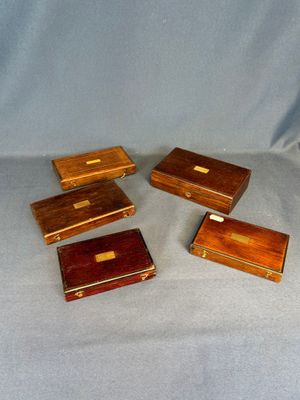 quatre petites boîtes en bois posées sur un tissu bleu