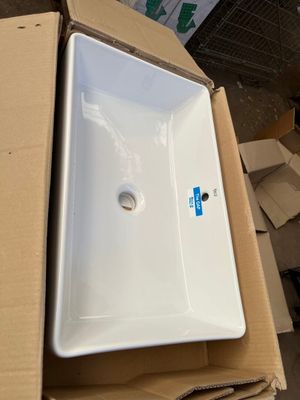 a white sink sitting on top of a cardboard box