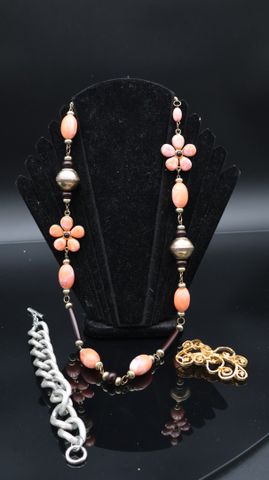 Un sautoir en perles orange (manque fermoir), une broche doré et ...