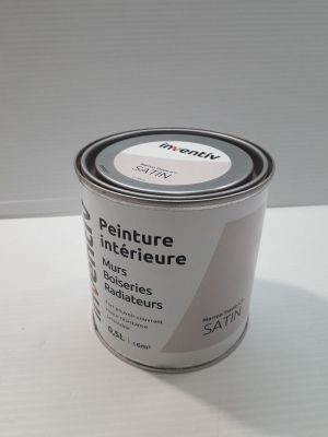 un pot de peinture posé sur une table, sur fond blanc
