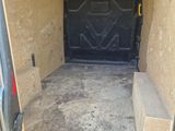 the inside of a van with the door open and a bench in the back