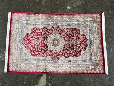 un tapis rouge et blanc orné d'un motif en médaillon
