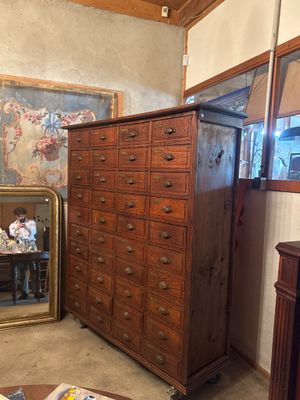 a dresser and a mirror in a room with a painting on the wall