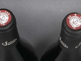 two bottles of wine sitting next to each other on a table