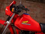 a red motorcycle parked in front of a brick wall