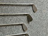several golf clubs are lined up in a row on the floor