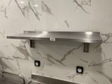 a stainless steel sink in a bathroom with marble walls