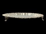 an antique silver plate on a stand against a black background