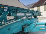 a blue crane that is parked in front of a building