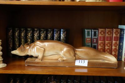 une statue représentant un chien allongé sur une étagère