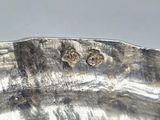 a close up of a silver plate with a pair of earrings on it