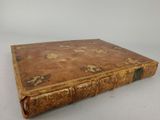 an old book sitting on top of a white surface