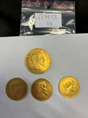 trois pièces d'or sont posées sur une feuille de papier