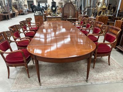 a large wooden table with red chairs in the middle of a room