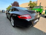the rear end of a black porsche parked in a parking lot