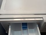 a white refrigerator that has a drawer in it