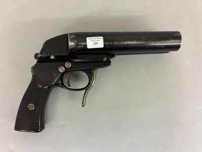 a close up of a gun on a table with a tag on it