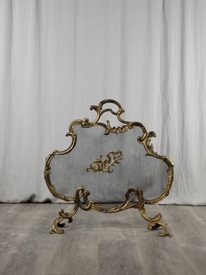 un pare-feu de cheminée richement décoré, orné d'un motif à la feuille d'or