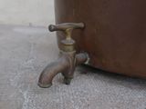 a faucet that is sitting on the ground next to a pot